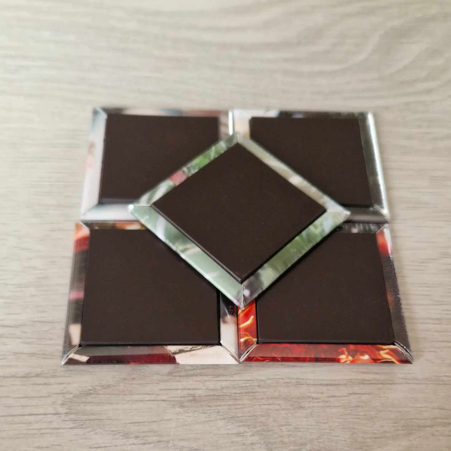 Five square magnets displayed with their reverse sides facing up. The backs are almost entirely covered with solid black magnetic material, showing a smooth and sturdy finish. They are arranged neatly on a flat surface.