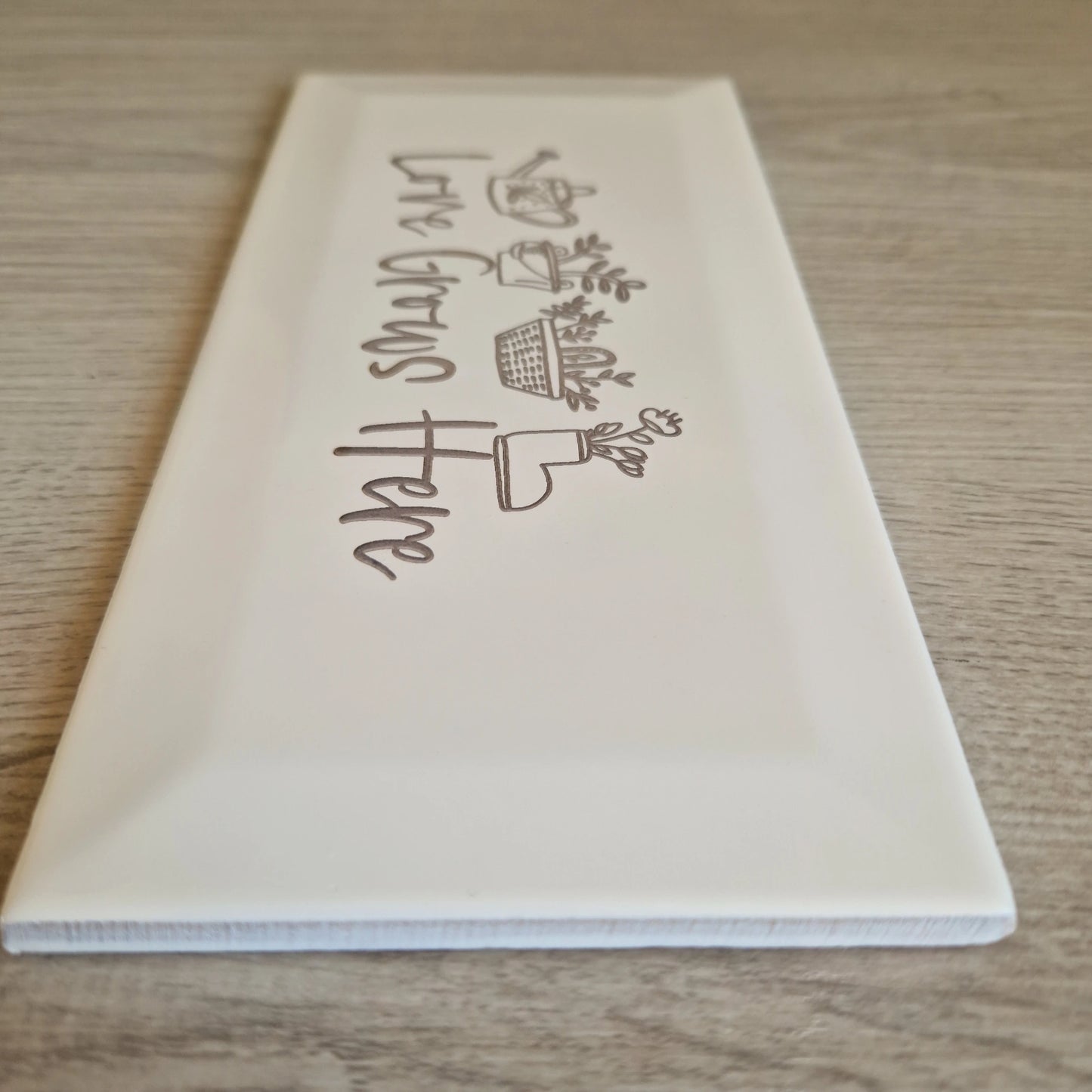 Side view of the engraved ceramic garden tile, highlighting its rectangular subway tile shape.