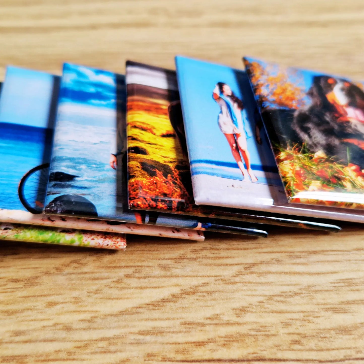 A single overlapping row of magnets, each magnet slightly positioned over the one next to it. The magnets display different designs or images, creating a dynamic, layered effect as they overlap.