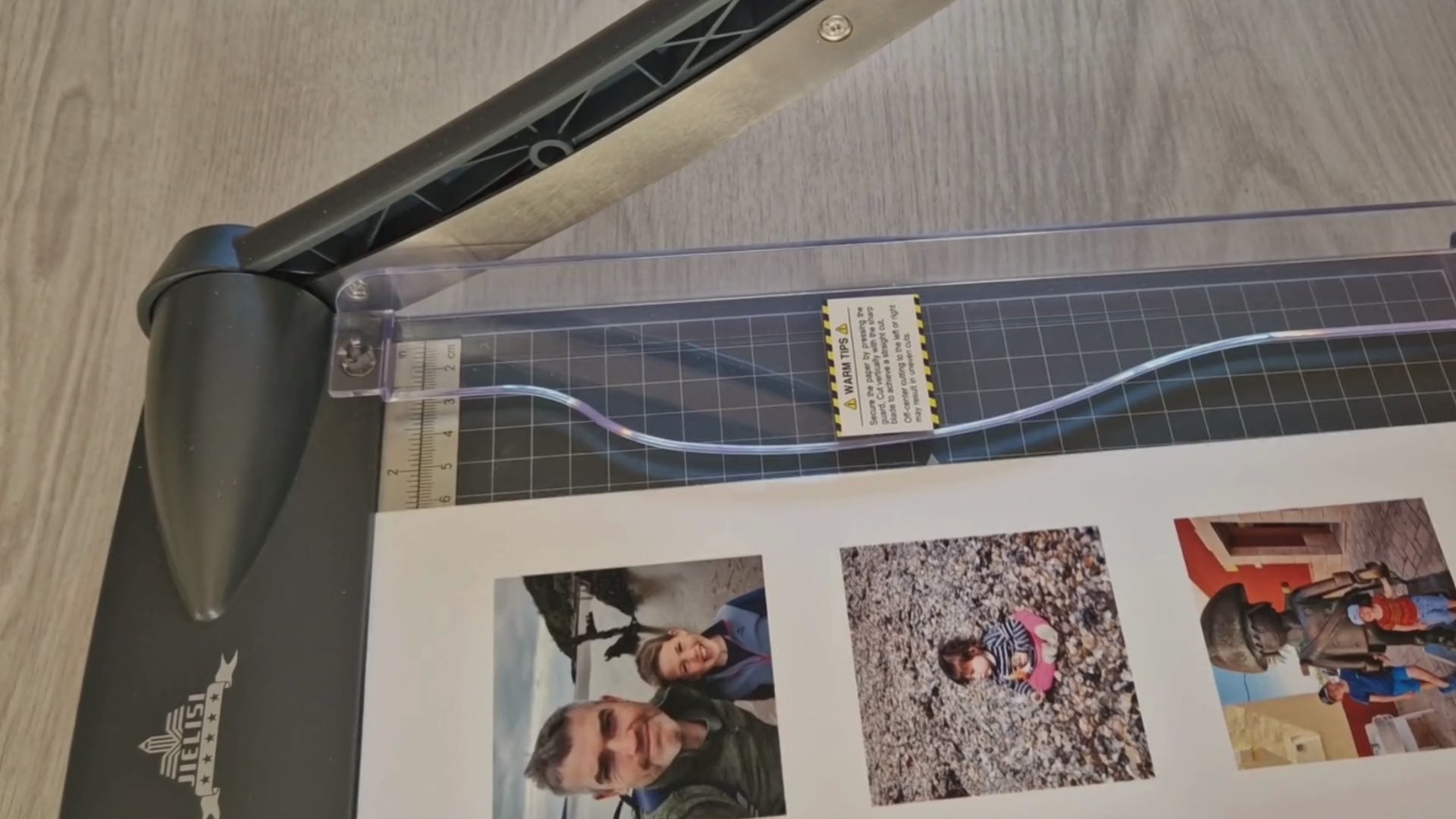 A video demonstrating the process of making custom fridge magnets. It starts with printed images being carefully cut to size, followed by the application of a protective layer. The images are then mounted onto a magnetic backing and pressed firmly for a secure bond. The final step showcases the finished magnets being displayed, highlighting their vibrant colors and glossy finish.