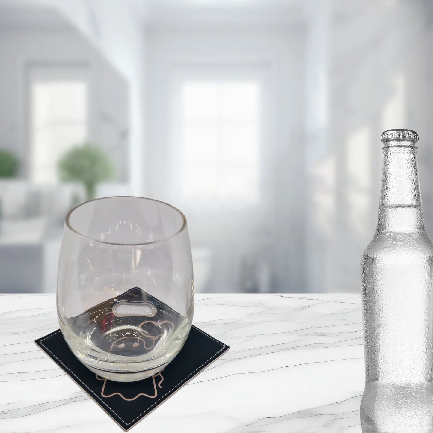 Leather coaster with a glass placed on it, sitting on a white counter.