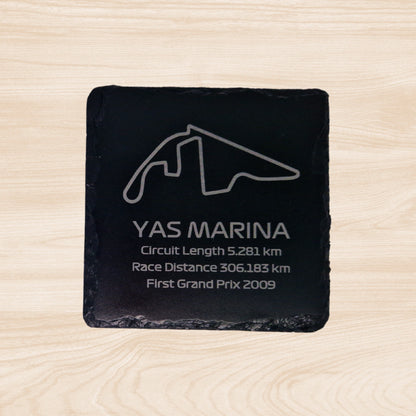 A black slate coaster featuring an engraved design of the Zandvoort racetrack. The engraving includes detailed outlines of the circuit, along with text listing the circuit length, race distance, and the year the track held its first Grand Prix. The sleek, engraved lines contrast with the natural rough texture of the slate, creating a unique, informative design.
